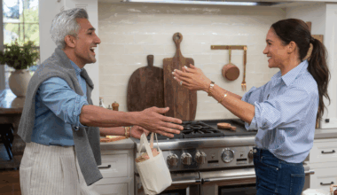 Meghan Markle putting her arms out to hug Tan France in a kitchen