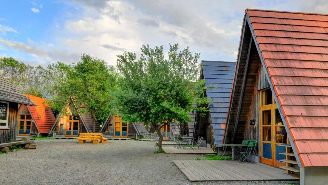 Wooden lodges at sunset in Legau, Germany, Triangular wooden lodges at an eco-resort in Legau, Germa