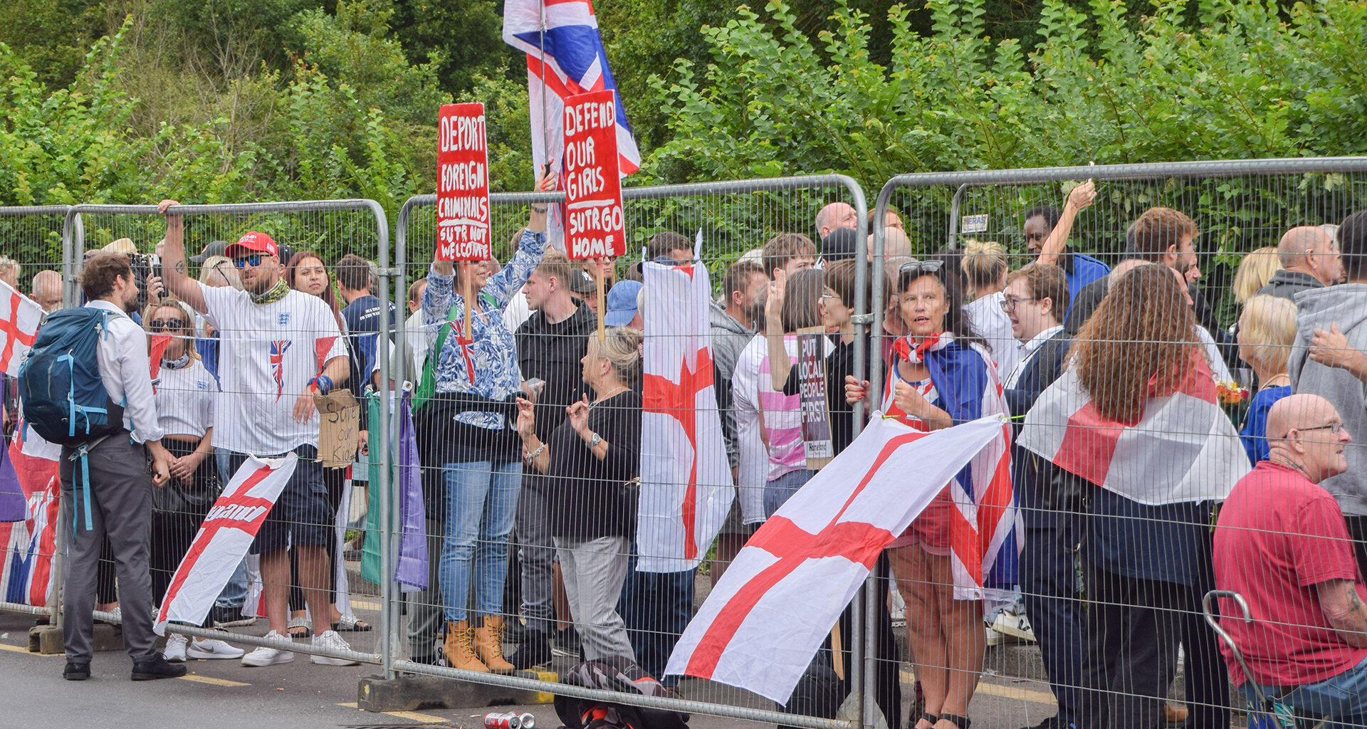 anti-immigration protesters behind a fence