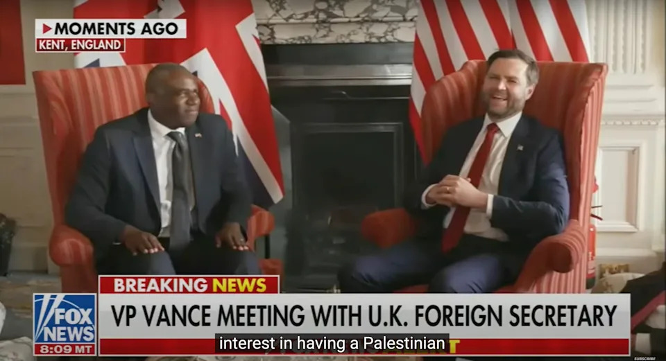 Two officials seated and smiling during a meeting, with a news banner stating "VP Vance Meeting with U.K. Foreign Secretary."