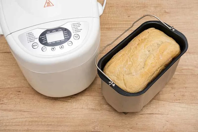 Bread mold inside the kneading barrel next to the domestic bread machine.