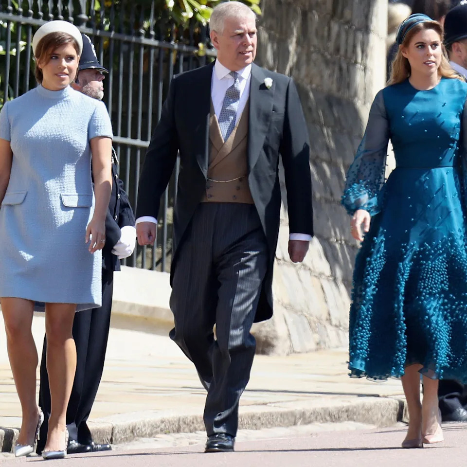 Princess Eugenie, Prince Andrew, and Princess Beatrice walk side by side towards St George's Chapel at Windsor Castle.