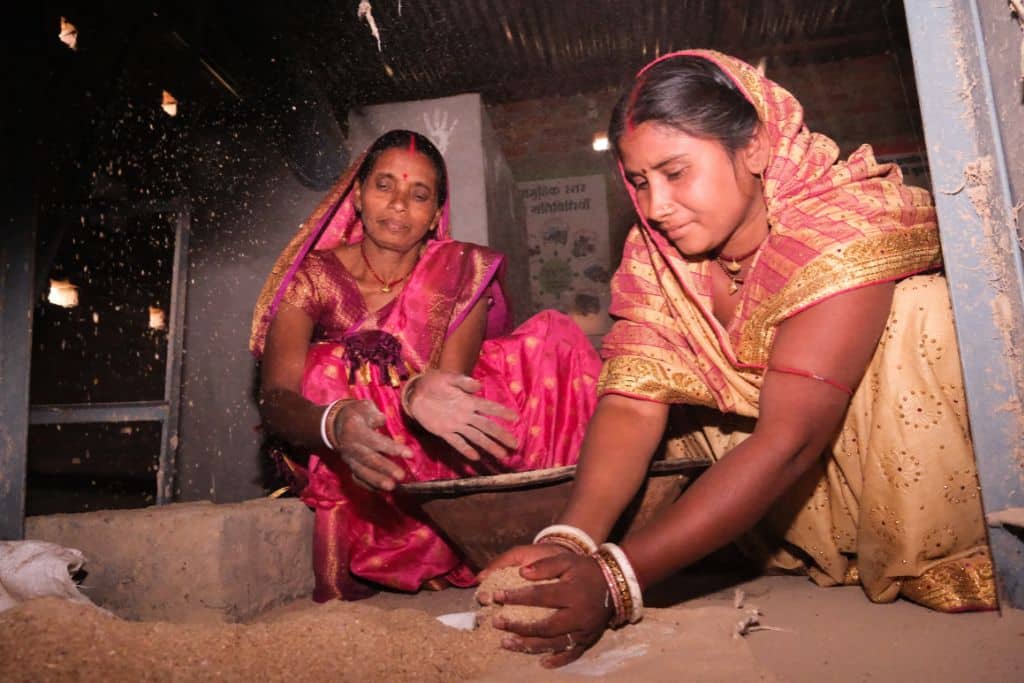 Sanju Devi (left), President of Bisfi’s FPO, and Sonia Devi (right) gather nutrient-enriched feed for goats at the FPO’s headquarters in Bisfi.