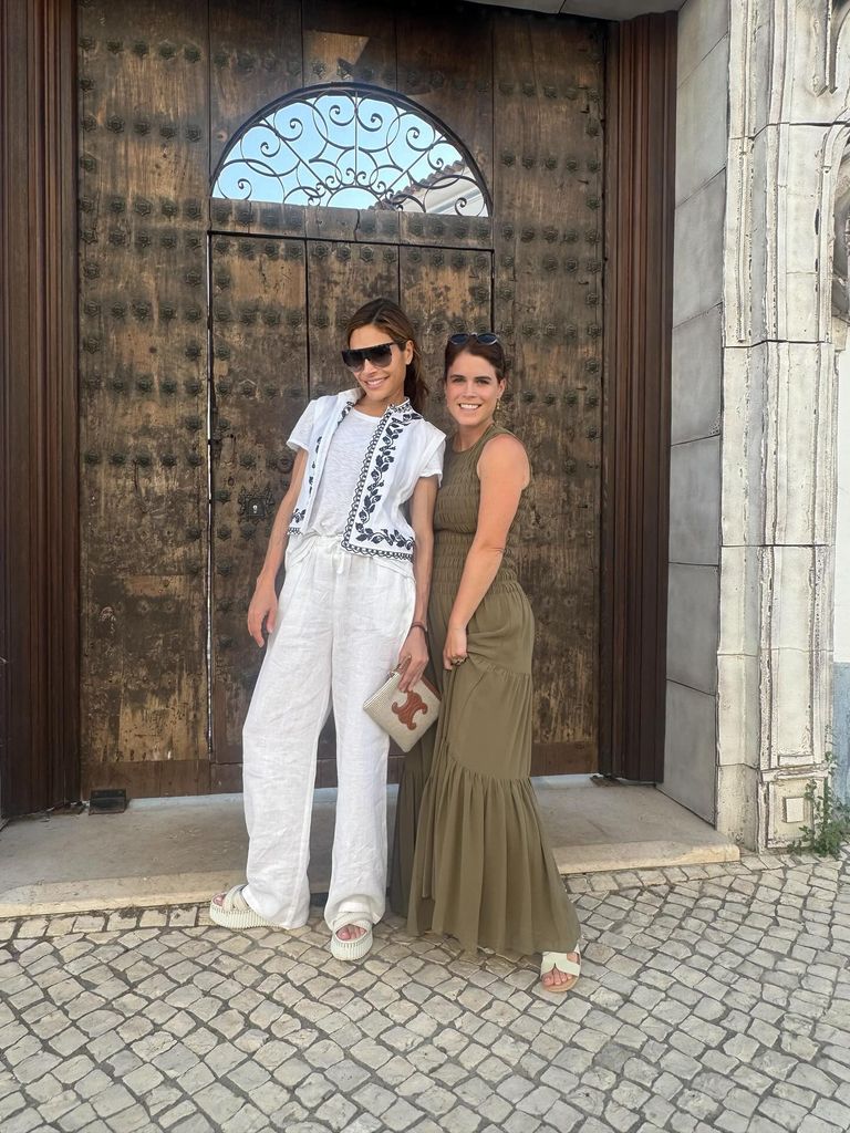Ayda Field and Princess Eugenie, wearing khaki dress, standing in front of gate