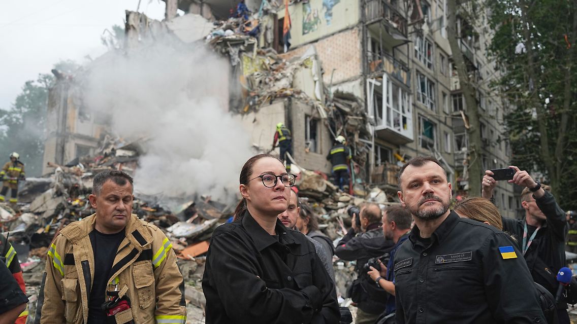 Durch einen Raketenangriff wird dieses Kiewer Wohnhaus zerstört. Zu sehen sind hier am Donnerstag die ukrainische Ministerpräsidentin Julia Swyrydenko, Innenminister Ihor Klymenko und Rettungskräfte.