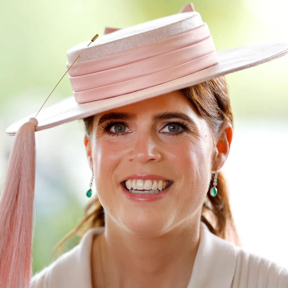 Princess Eugenie wearing a pink hat and smiling.