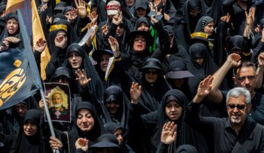 Iranians, including one holding an image of a general killed in an Israeli attack, march during a Tasua ceremony, a day for Shia Muslims of mourning and commemoration of martyrdom, in Tehran on July 5.