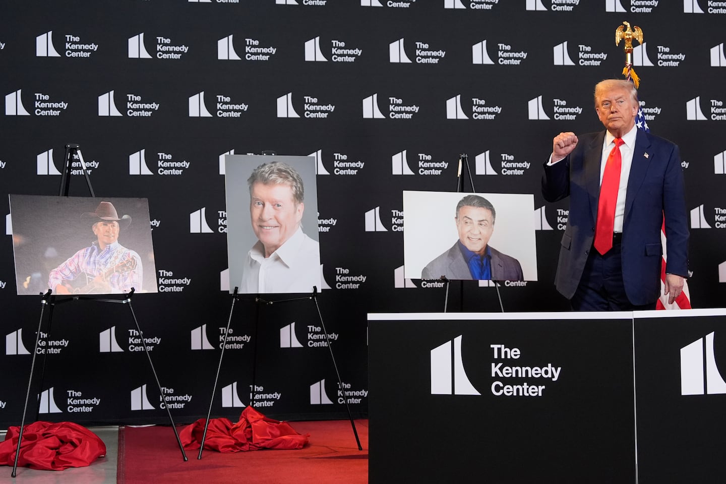 President Trump stands beside photos of Kennedy Center Honors nominees from left showing, country music star George Strait, actor-singer Michael Crawford and "Rocky" actor Sylvester Stallone.