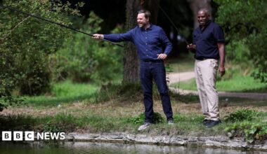 Foreign Secretary David Lammy fishing with US vice president JD Vance at Chevening House in Kent. Both men are wearing blue shirts, JD Vance is in jeans and Lammy is in beige chinos.
