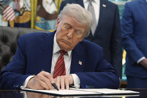 U.S. President Donald Trump signs an executive order regarding nuclear energy in the Oval Office of the White House on May 23 in Washington. [AP/YONHAP]