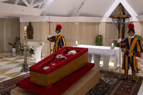 Getty Images Members of the Swiss Guard stand over Pope Francis's body in the chapel - 21 April 2025