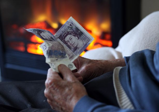 In this photo illustration, an elderly man holds cash in his hands as he warms himself in front of a fire on October 6, 2011 in Bristol, England. Energy price rises and an increase in the cost of living has resulted in more people, including the elderly, with energy debts with a reported rise of a quarter for electricity and a fifth for gas bills.   (Photo by Matt Cardy/Getty Images)