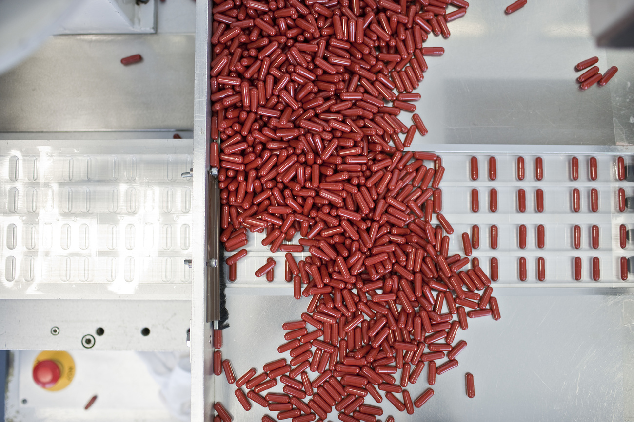 A machine dispenses pharmaceutical capsules into blister packs.