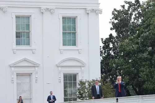 President Donald Trump shouts answers to questions from reporters as he tours the roof of the West Wing of the White House on August 05, 2025 in Washington, DC.