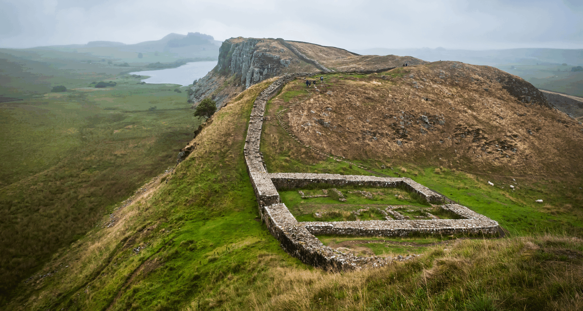 a series of small walls in a lush, mountainous landscape