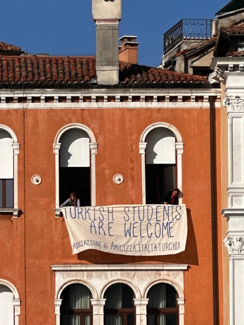 Members of the Italy-Türkiye Friendship Association support the protest of Turkish students and parents at Ca' Foscari University in Venice by holding a banner reading