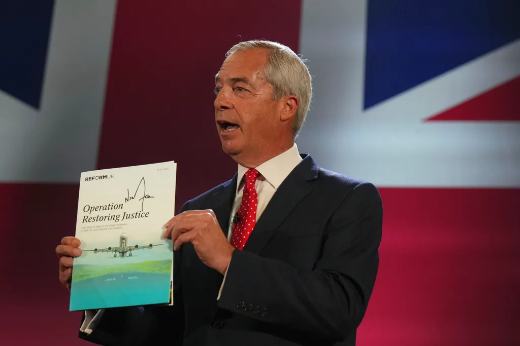 British Reform UK party leader Nigel Farage shows the program Operation Restoring Justice during a press conference in a hangar at Oxford Airport in Kidlington, England, Tuesday, Aug. 26, 2025.