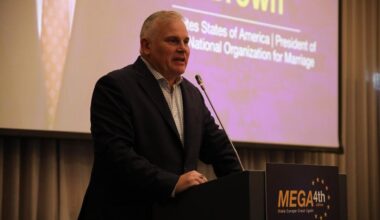 Brown standing behind podium speaking at MEGA 4th edition in Moldova