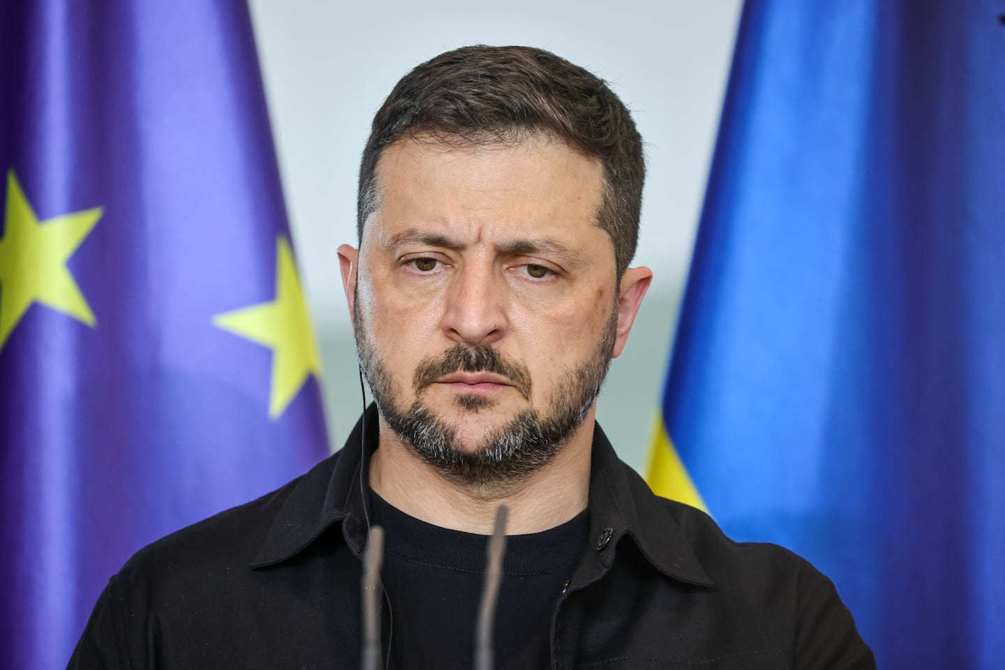 Ukrainian President Volodymyr Zelensky listens as German Chancellor Friedrich Merz (not pictured) speaks during a joint press conference at the Chancellery following a virtual meeting hosted by Merz between European leaders and US President Trump on August 13, 2025 in Berlin, Germany.
