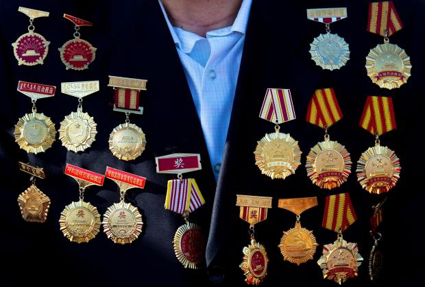 FILE – A guest of honor with medals on his...