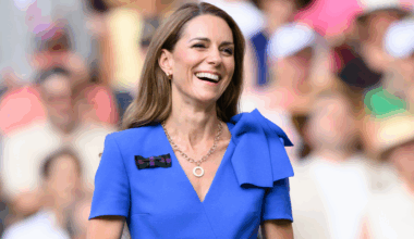 Kate Middleton laughing and wearing a blue dress at Wimbledon