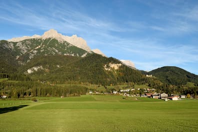 Blick auf Wiesen, Berge und Häuser in der Region Saalfelden in Salzburg.