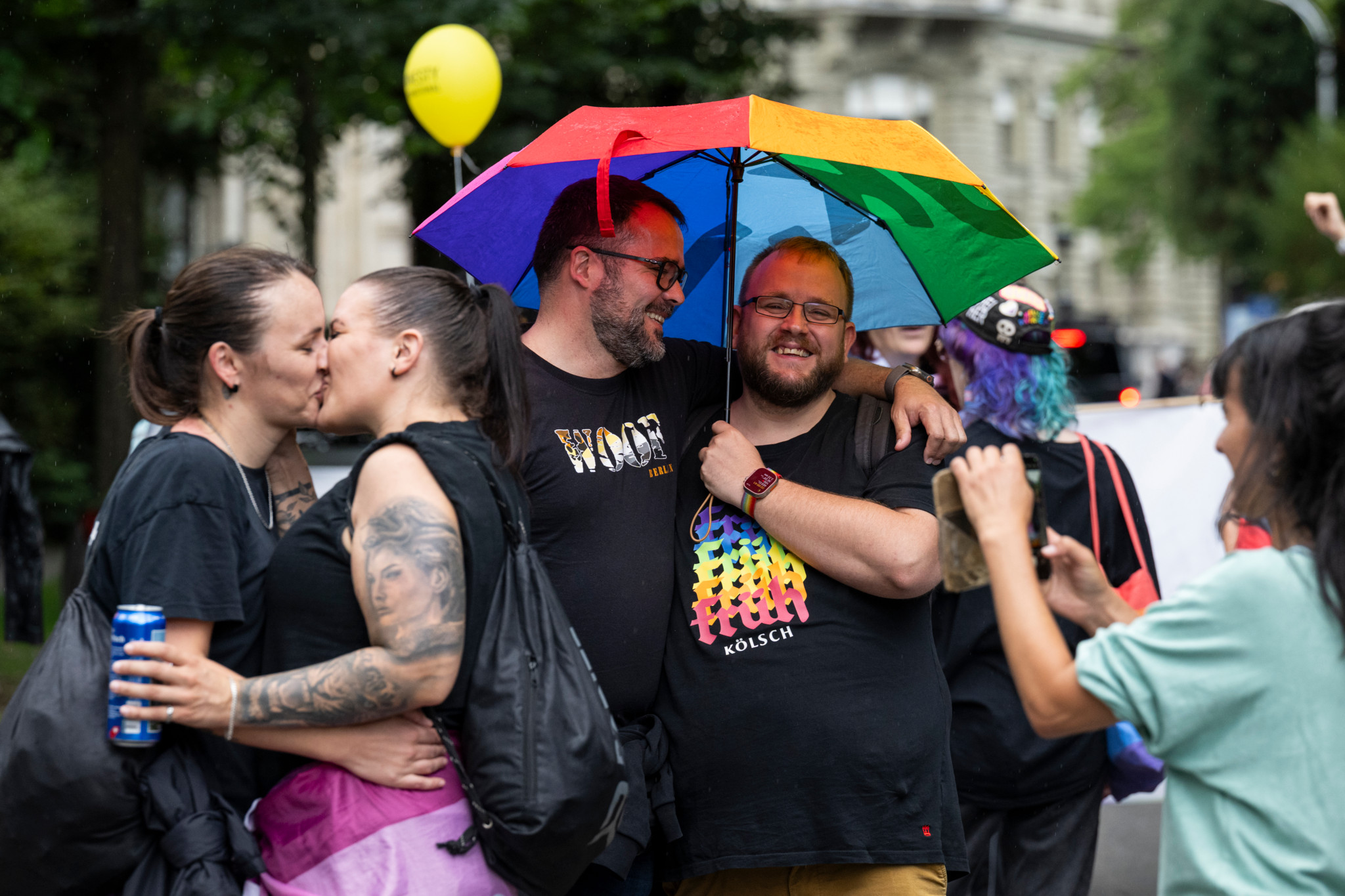 Teilnehmer der BernPride 2025 in Bern unter einem Regenbogenschirm, lächelnd und sich umarmend, umgeben von Festivalbesuchern. Teilnehmer der BernPride 2025 in Bern unter einem Regenbogenschirm, lächelnd und sich umarmend, umgeben von Festivalbesuchern.