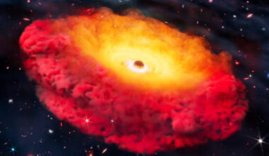 A black hole with a giant reddish golden cloud around it sits in the darkness of space