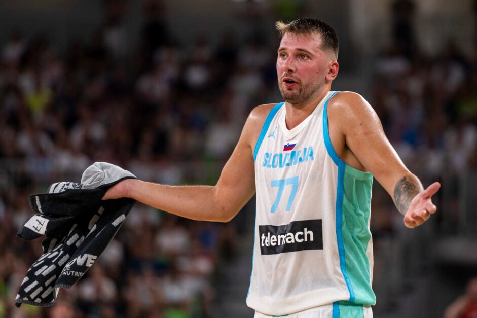 Luka Doncic gestures, for Slovenia, holding black and grey towel.