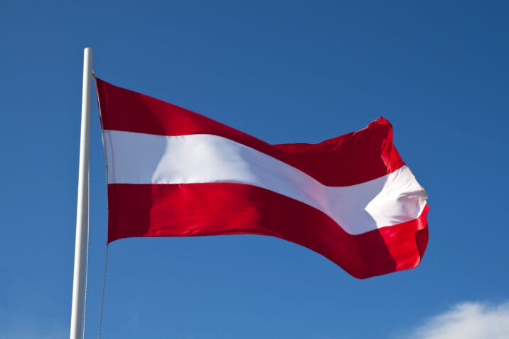 Hoisted flag of Austria on blue sky background Austrian flag waving in the wind