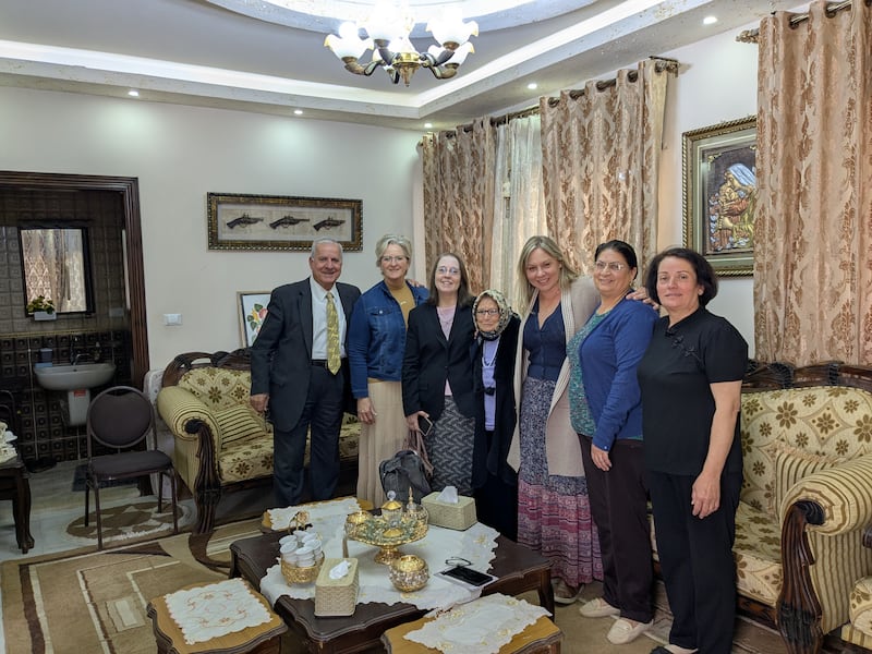 Rizek and Wendy Housari, far left, pose for a photo with women after Relief Society in May 2025. Rizek Housari translates Arabic for individuals who attend Relief Society.