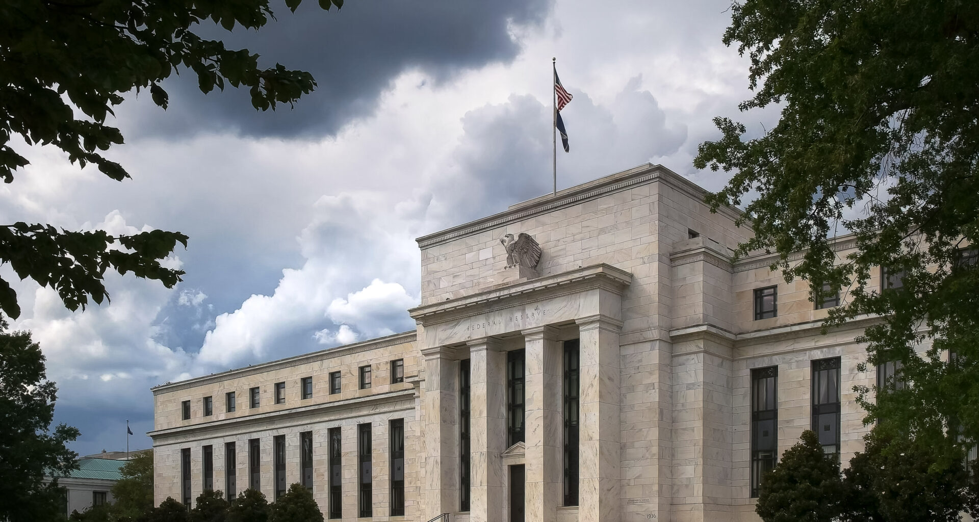 the federal reserve building in washington dc under gathering storm clouds