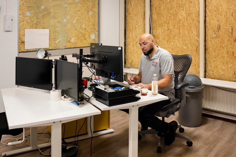 Security guard Jonathan Lindenkamp, sits next to shattered glass and boarded up windows in a surveillance room at the Lunaweg in Amsterdam, the Netherlands. Photograph: Ilvy Njiokiktjien for The New York Times