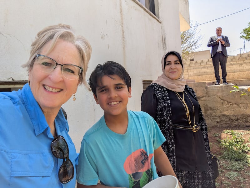 Wendy Housari takes a selfie with a family that received chickens and incubators from Latter-day Saint Charities in Jordan in April 2025.