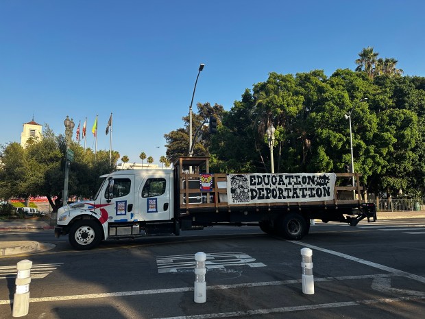 A truck with a sign reading “education not deportation” sits...