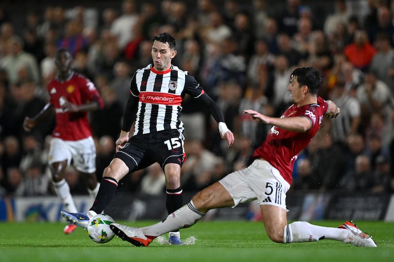 Grimbsy's Geza David Turi is challenged by Manchester United's Harry Maguire. Photograph: Shaun Botterill/Getty Images