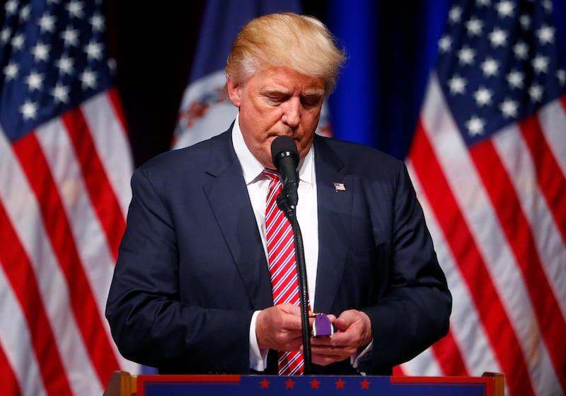Donald Trump holds a Purple Heart given to him during a campaign event at Briar Woods High School in Ashburn, Virginia, U.S., August 2, 2016. REUTERS/Eric Thayer