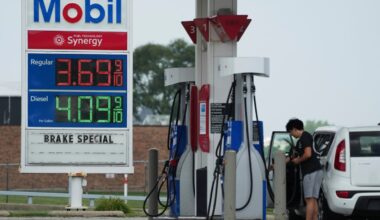 A man checked gas prices before he filled up his vehicle's gas tank at a gas station in Prospect Heights, Ill.