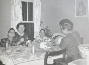 In this undated photo, Pope Leo XIV (then Robert Prevost) (left) smiles while his mother (back to the camera) cuts a birthday cake in what his brother (right) guessed was the pope