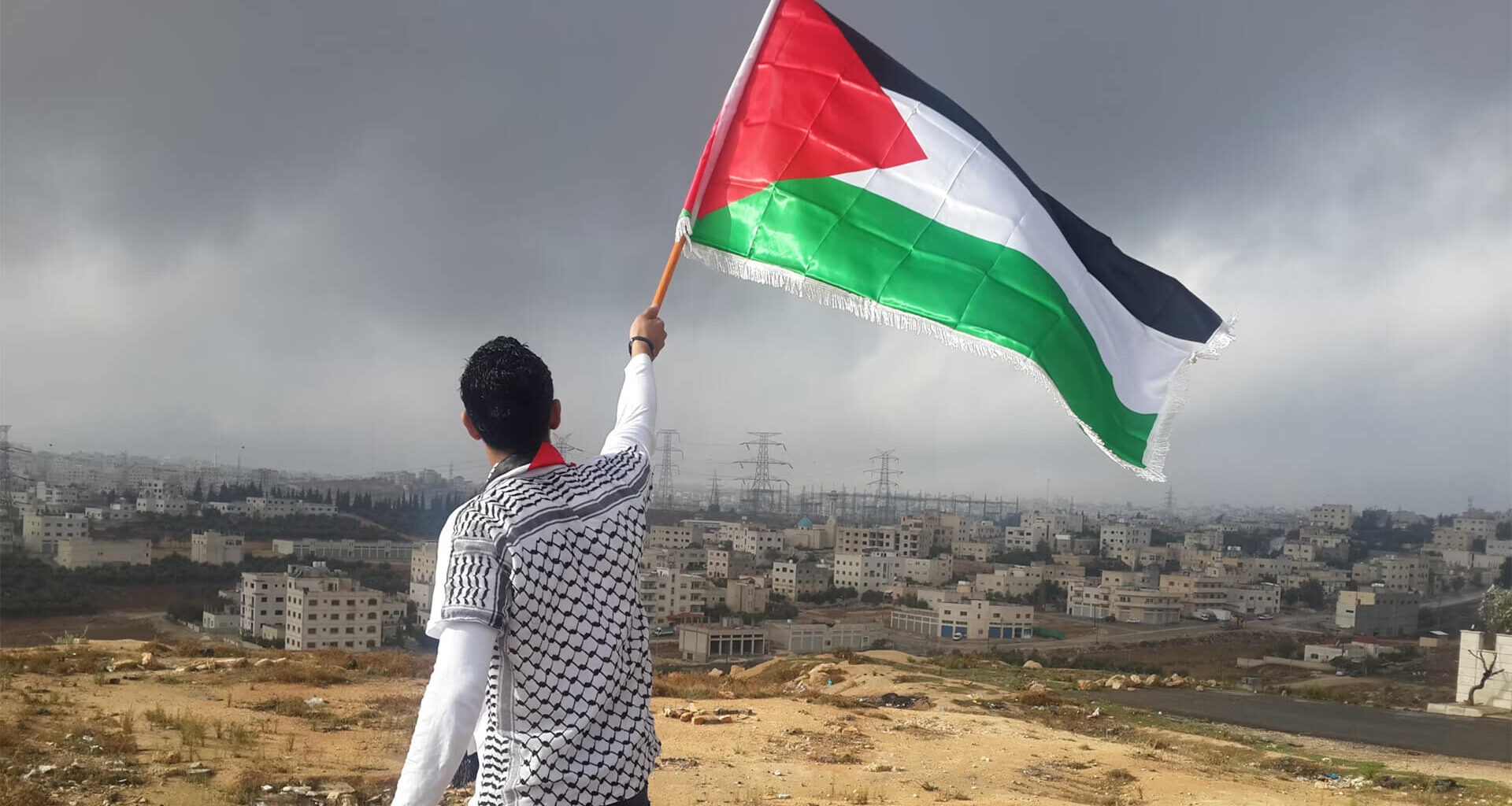 Man waving the Palestinian flag over Gaza