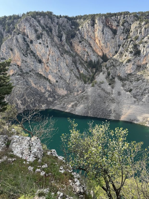 A blue lake below a mountain.
