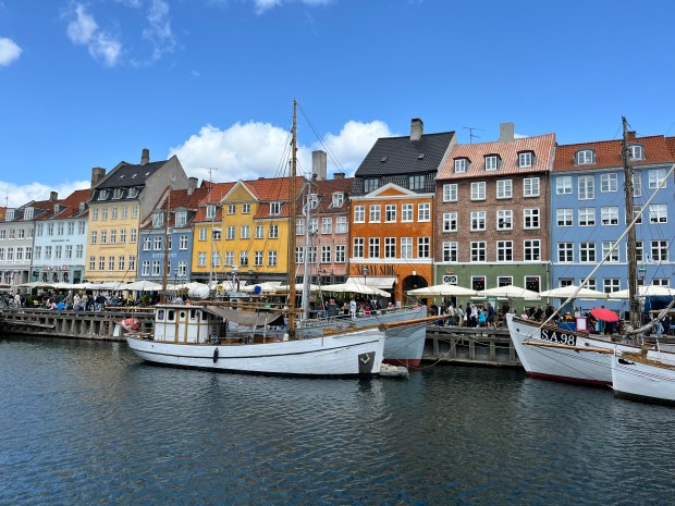 Colorful houses in Copenhagen with sailboats in the foreground