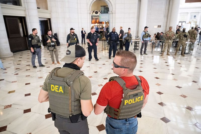 Law enforcement officials stand guard outside of Shake Shack while US Vice President JD Vance, Defense Secretary Pete Hegseth and White House Deputy Chief of Staff Stephen Miller (not pictured) visit with members of the National Guard stationed at Union Station in Washington, DC, on August 20, 2025. US President Donald Trump on August 11 deployed military and federal law enforcement to curb violent crime in Washington, as he seeks to make good on his campaign pledge to be a "law and order" president. The Republican leader said he would place the city's Metropolitan Police under federal government control while also sending the National Guard onto the streets of the US capital. (Photo by SAUL LOEB / AFP) (Photo by SAUL LOEB/AFP via Getty Images)