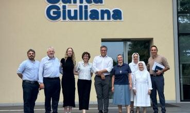 Taylor Begin with group, including nuns, in front of hospital in Milan