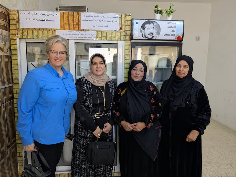 Wendy Housari poses for a photo with women who received training and supplies from the Church to be able to sell yogurt and goat cheese in April 2025.