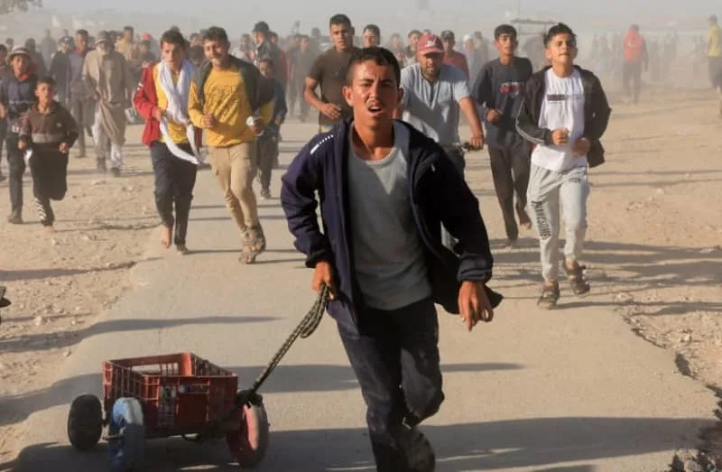 Palestinians walk to collect aid supplies from the Gaza Humanitarian Foundation, in Khan Yunis, in the southern Gaza Strip, May 29, 2025 (credit: REUTERS/Hatem Khaled)