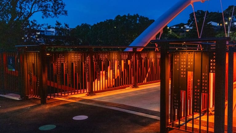  At night, the bridge glows with moving colour, shaped by the natural elements.
