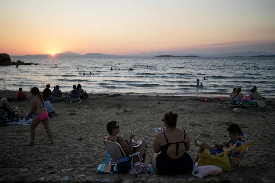 People gather at Kavouri beach as the sun sets in southern Athens, Greece, Monday, Aug. 11, 2025. (AP Photo/Thanassis Stavrakis) (Copyright 2025 The Associated Press. All rights reserved)