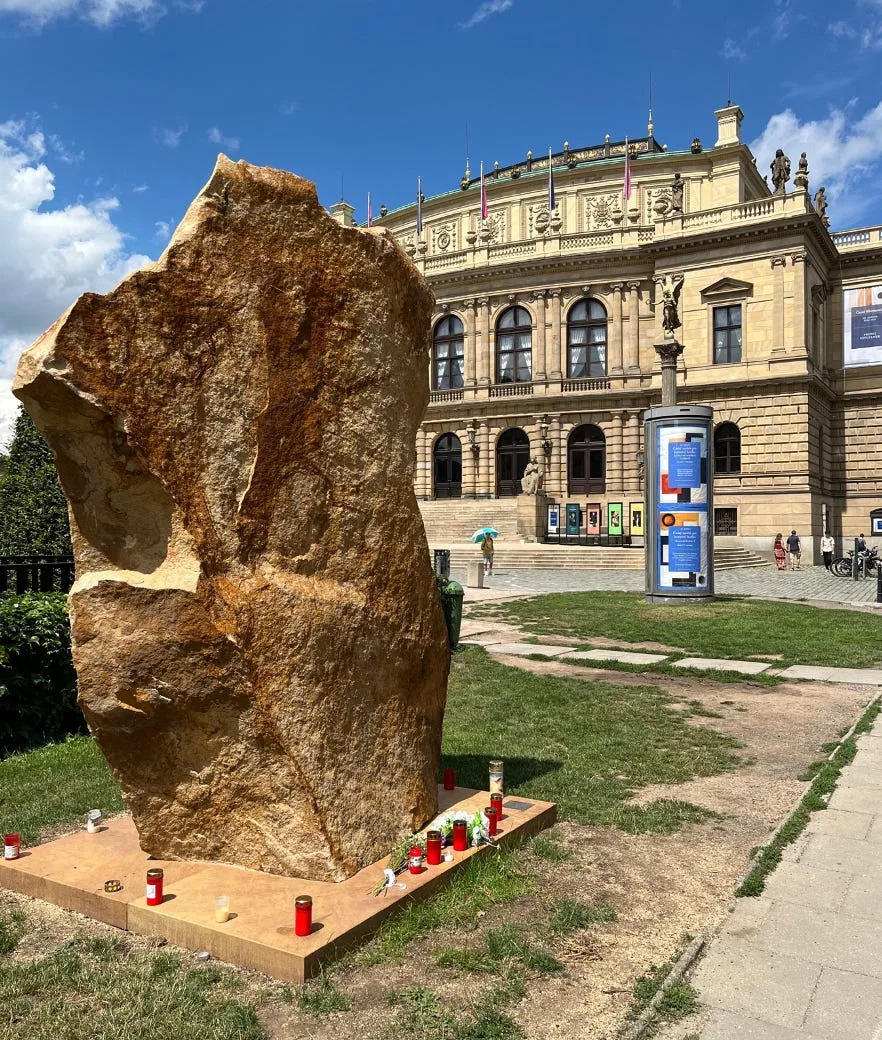 A stone memorial in downtown Prague honors the 14 people killed and 22 wounded in a shooting at the close of 2023.