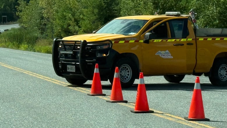 A yellow car is seen blocking traffic on the road.